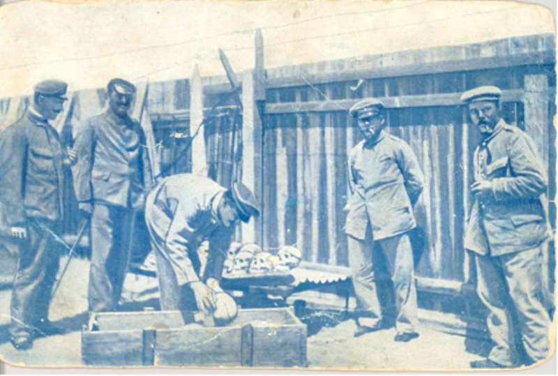 German soldiers loading human skulls and bones of massacred Hereros into a casket for shipping to German universities, especially, Berlin.