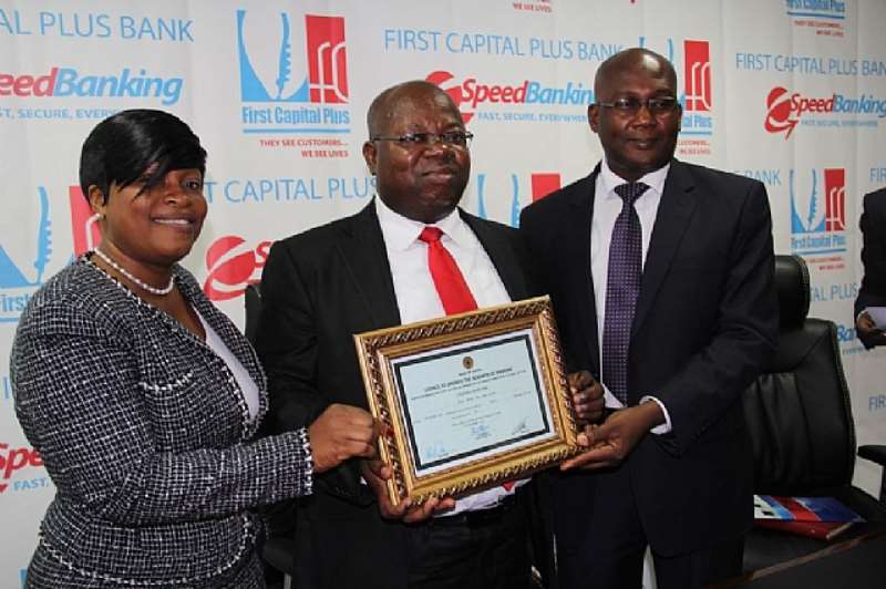 CEO Of First Capital Plus, John Kofi Mensah (Middle) Displaying The Universal Banking Certificate At The Press Conference. With Him Is Gifty Gosu (Left) GM Business Banking And Dr. Charles Akuetteh (Right) GM Risk Management