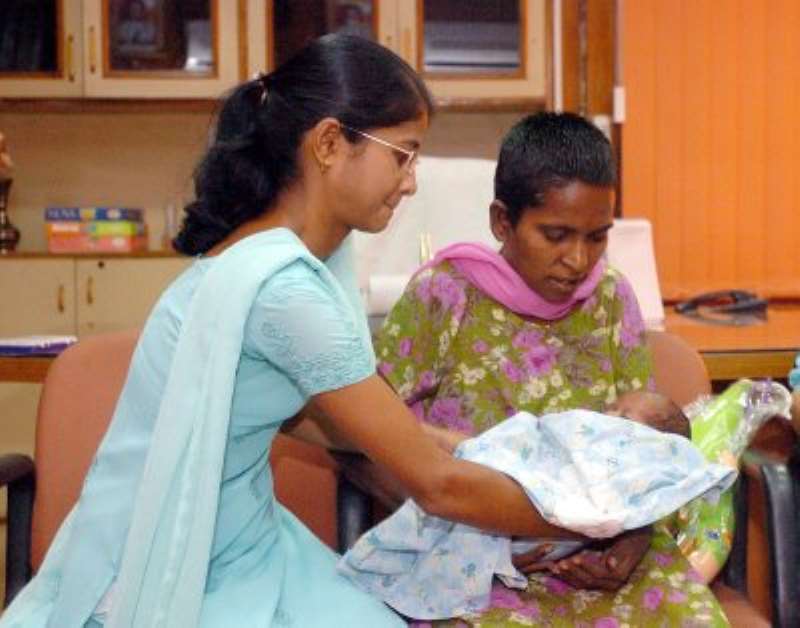 Saraswati being given her son for the first time since his birth.