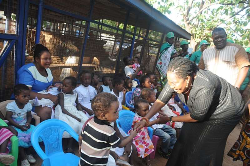 MRS LORDINA MAHAMA SHAKES THE HAND OF A CHILD AT TAMALE ORPHANAGE BEFORE PRESENTING FOOD ITEMS TO THE HOME