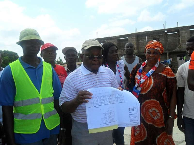 prof oquaye displaying the plan of the hospitail