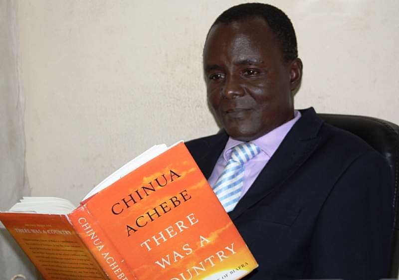 Ugochukwu Ejinkeonye with the book, There Was A Country, By Chinua Achebe