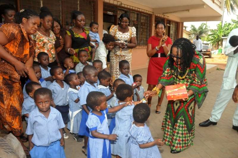 FIRST LADY MRS LORDINA MAHAMA SHARING CHOCOLATE TO THE CHILDREN AT OSU CHILDRENS HOME