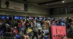 Ghanaian nationals stand at the check-in desk for an evacuation flight at OR Tambo International Airport, outside Johannesburg.  By Phill Magakoe (AFP)