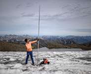 Matthias Huss with a four-metre-long measuring stake indicating the amount of ice that melted over the past year on the Scex. Rouge glacier - Fabrice COFFRINI / AFP