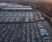Cars are parked as a cargo train drives past the Duisport Logport logistics center in Duisburg, Germany, on September 27, 2026. - Michael Sohn, AP