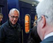Ukrainian Foreign Minister Andrii Sybiha receives German Chancellor Friedrich Merz as he arrives at a railway station in Kyiv on October 4, 2026. - Alina Smutko, Reuters