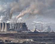 Mining vehicles extract coal from a lignite coal mine, as the Elbistan thermal power plant, is seen in the background in Elbistan on 11 February 2026. - Ozan KOSE / AFP/File