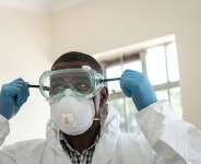 A specialist healthcare worker prepares his PPE before visiting an isolation ward for people who had close contact with the first Kenyan Covid-19 patient at Kenyatta National Hospital in Nairobi, Kenya on 15 March 2020.  AFP