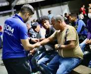 IOM staff helping migrants and refugees from Venezuela before boarding a relocation flight from Boa Vista in southern Brazil. Photo: IOM/Gema Cortes