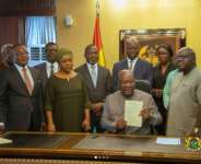 President John Mahama, surrounded by a number of his appointees, during a brief ceremony to sign the bill into law (Source: Myjoyonline)