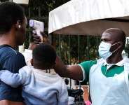 A health official uses a thermometer to screen people in front of Kibuli Muslim Hospital in Kampala, Uganda, Saturday, May 16, 2026. -  Hajarah Nalwadda, AP
