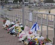 A woman stands at a flower tribute at Bondi Beach in Sydney, Australia, on December 16, 2025. -  Mark Baker, AP