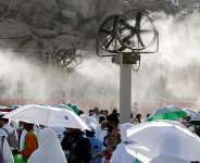 Pilgrims gather near misting fans at the Mount of Mercy on the plain of Arafat during the annual hajj pilgrimage, outside Mecca, Saudi Arabia, 26 May. - REUTERS - Ibraheem Abu Mustafa