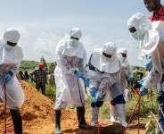 Red Cross workers bury an Ebola victim at the Rwampara Cemetery, in Rwampara, DR Congo, May 23, 2026. - Moses Sawasawa, AP