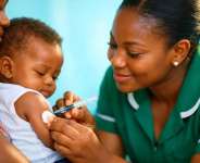 A Ghanaian nurse administering a malaria vaccine to an infant.