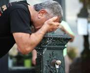 A man cools off at a public fountain in Paris on June 18, 2026. -  Simon Wohlfahrt, AFP