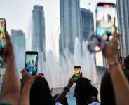 Since the start of the war in the Middle East, the Gulf States have severely restricted their rules on freedom of speech, sometimes punishing citizens for publishing videos and content related to the war. Here, people film the Dubai fountain, 27 May 2026 (illustration). -  Fatima Shbair / AP