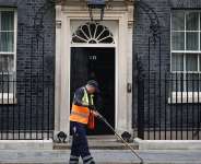 A street cleaner sweeps the gutter outside 10 Downing Street on the morning of June 22, 2026, ahead of Prime Minister Keir Starmers resignation announcement. -  Henry Nicholls, AFP