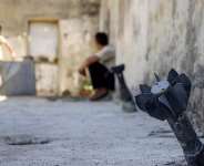 A man speaks with a child while sitting near an unexploded artillery shell that fell during reported overnight Israeli bombardment that hit the village of Abidin in Syrias southwestern Daraa province, close to the Golan Heights, on June 29, 2026. -  AFP, Sam Hariri