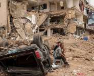 Residents sit amid the rubble of a neighbourhood in the southern Lebanese city of Tyre after an Israeli strike on 18 April 2026. Months of war have displaced more than a million people and deepened political divisions across Lebanon. -  Louisa Gouliamaki / Reuters