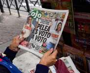 A newspaper vendor reads the front page of a newspaper that reads in Spanish: The fight is vote by vote in Lima, Peru, Monday, June 8, 2026, a day after the presidential election runoff. -  Rodrigo Abd, AP