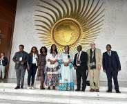 Dr. Ergogie, Minister of Women and Social Affairs, standing fourth from right, in front of the conference hall.