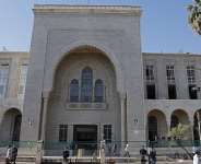 People walk past security personnel standing guard outside the Palace of Justice ahead of the first trial session, in Damascus on April 26, 2026. -  Bakr Alkasem, AFP