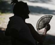 A man fans himself as he rests on a hot day in Retiro Park in Madrid, Spain, 28 June, 2025. - AP - Paul White