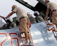 Russian ground staff members check on a Sukhoi Su-30 fighter jet at the Hmeymim air base near Latakia - REUTERS