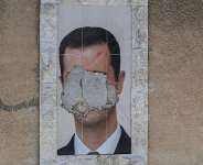 A defaced portrait of Syrias ousted president Bashar al-Assad on a wall in the capital Damascus, 2 June, 2025. - AFP - LOUAI BESHARA