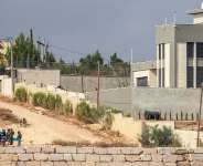 Israeli soldiers are seen as Israeli settlers set-up a tent just outside the entrance of a besieged Palestinian family home in the village of Qusra, south of the city Nablus, in the Israeli-occupied West Bank, on August 14, 2026. -  Jaafar Ashtiye, AFP