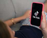 A teenager holds her smartphone displaying the logo of Chinese social network Tik Tok in Brussels on July 7, 2026. -  Nicolas Tucat, AFP