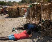Migrants rest next to makeshift shelters in Ceuta on August 15, 2026. -  Jorge Guerrero, AFP