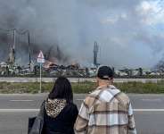 People watch the burning Wildberries warehouses following a Ukrainian drone attack, according to the regional governor, in the course of the Russia-Ukraine conflict, in Koledino, Moscow Region, Russia August 16, 2026. -  Stringer, Reuters