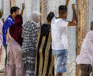 Families watch as migrants return after crossing the border into the Spanish enclave of Ceuta, at the Bab Ceuta border post near the town of Fnideq, Morocco on August 2, 2026. -  Abdel Majid Bziouat, AFP