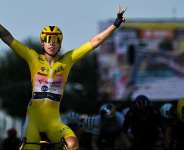 Team SD Worx-Protimes Dutch rider Lorena Wiebes wearing the overall leaders yellow jersey celebrates as she crosses the finish line to win the second (out of 9) stage of the fifth edition of the Womens Tour de France cycling race, in Geneva on August 2, 2026. -  Nicolas Tucat, AFP