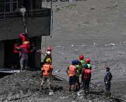 Police personnel rescue stranded residents from houses lying deluged in sludge after flash floods at Trishuli in Nepals Nuwakot district on August 27, 2026. - Arun Sankar, AFP