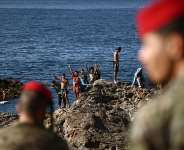Members of the Spanish Armys Regulares infantry forces watch a group of migrants near the border post of the Spanish enclave of Ceuta on 2 August 2026. - AFP - HENRY NICHOLLS