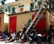 Migrants sit outside the CETI short-stay migrant centre in the Spanish North African enclave of Ceuta. -  Henry Nicholls / AFP/File