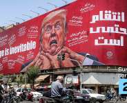 A woman walks past a large billboard pledging revenge against US President Donald Trump along Jomhouri Street in central Tehran on July 27, 2026. -  AFP