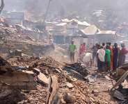 People walk through smoke after the fire at a school in Bukavu killed at least 27 children. -  Janvier Barhahiga / AP