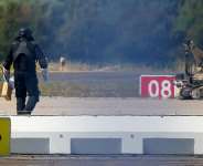 A police officer in protective clothing walks next to an explosive-disarming robot at Leipzig/Halle Airport in Schkeuditz, Germany, August 5, 2026. -  Axel Schmidt, Reuters