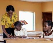 A female teacher helping a pupil in a classroom