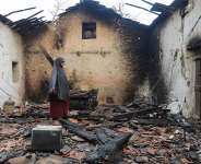 A woman inspects her damaged house after it was burned down in a forest fire in Bordj Thar, a town and commune in Algerias northeastern Jijel Province, 27 August. - AFP - -