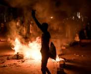 A demonstrator stands next to a burning barricade during a protest over The Gambias electricity crisis. By Muhamadou BITTAYE (AFP)
