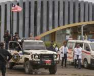 Des policiers montent la garde prs dun avion transportant des migrants expulss des tats-Unis,  laroport international Roberts de Harbel, prs de Monrovia, le 20 aot 2026 au Liberia.  By Matthew Jacobs (AFP)