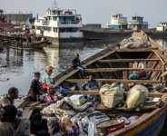 Families wait in a boat with their belongings on the shores of Lake Kivu in Bukavu as thousands flee the conflict. By Luis TATO (AFP/File)