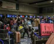 Ghanaian nationals stand at the check-in desk for an evacuation flight at OR Tambo International Airport, outside Johannesburg.  By Phill Magakoe (AFP)