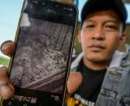 Indonesian fisher Jamaludin shows a photo of shark fins, taken during his time working on a Chinese tuna longliner, as he spoke to AFP near Cirebon, West Java.  By Bay ISMOYO (AFP)